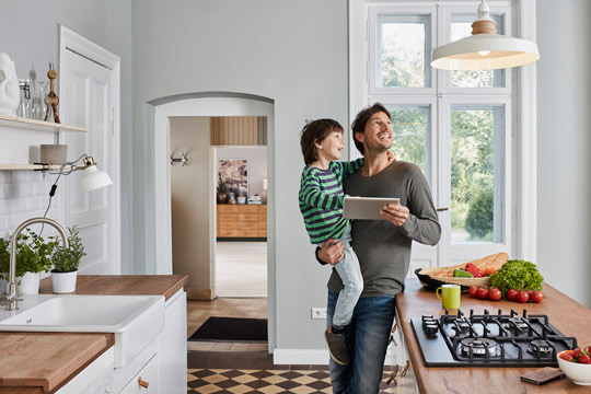 Man turning on lights with connected device protected by Assurant