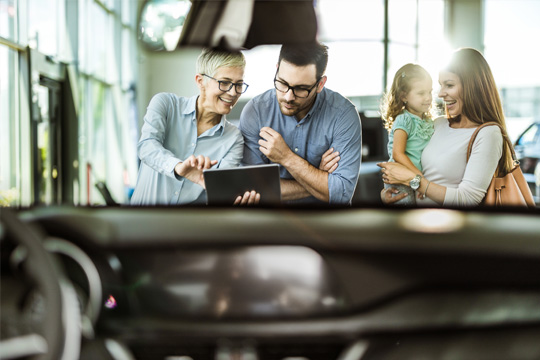 A family at the dealership looking at paperwork