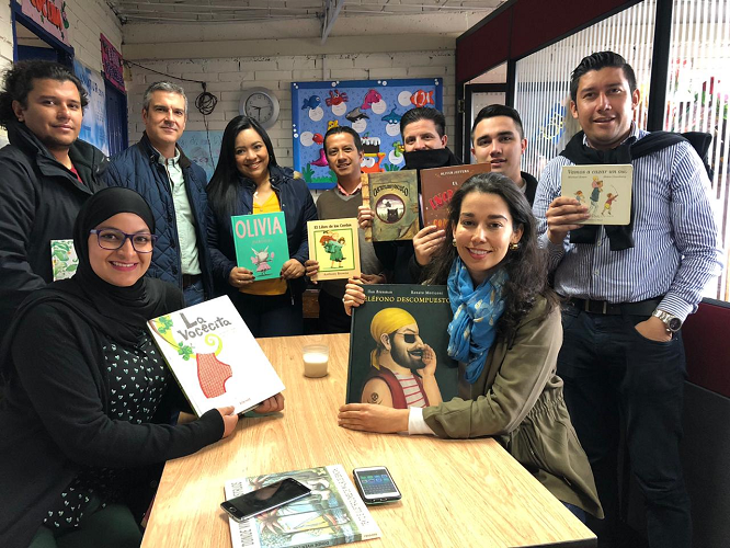 Diverse Group of Assurant Employees Holding up Books